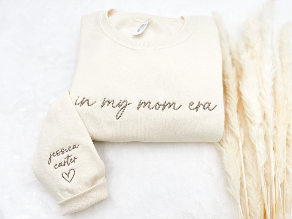 “In My Mom Era embroidered sweatshirt with custom kids’ names on sleeve – neutral cream tone”