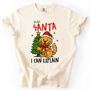 Ivory t-shirt with “Dear Santa I Can Explain” text and cute dog in Santa hat beside Christmas tree