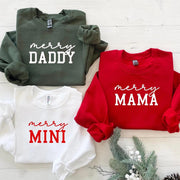 Matching Christmas sweatshirts in red, white, and green with text “Merry Daddy”, “Merry Mama”, and “Merry Mini”